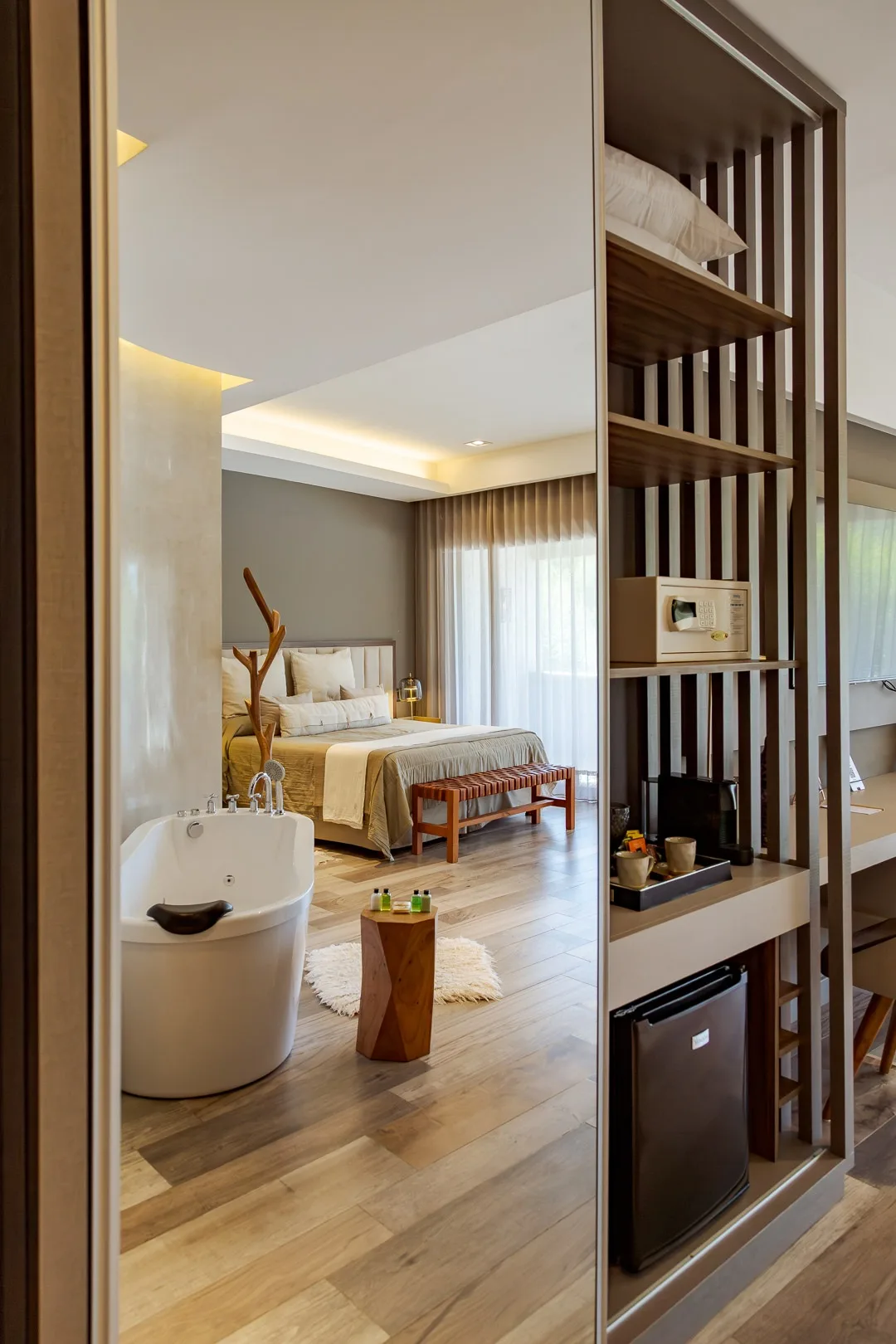 Habitación del Domingo Design Hotel vista desde la entrada, con bañera exenta, cama y mueble con frigobar